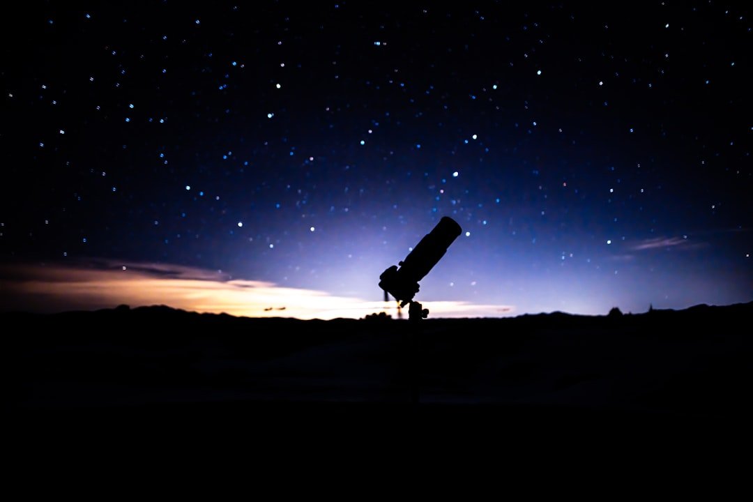 Telescópio sob céu estrelado, imagem ilustrativa para notícia sobre impacto de espelhos espaciais no céu noturno